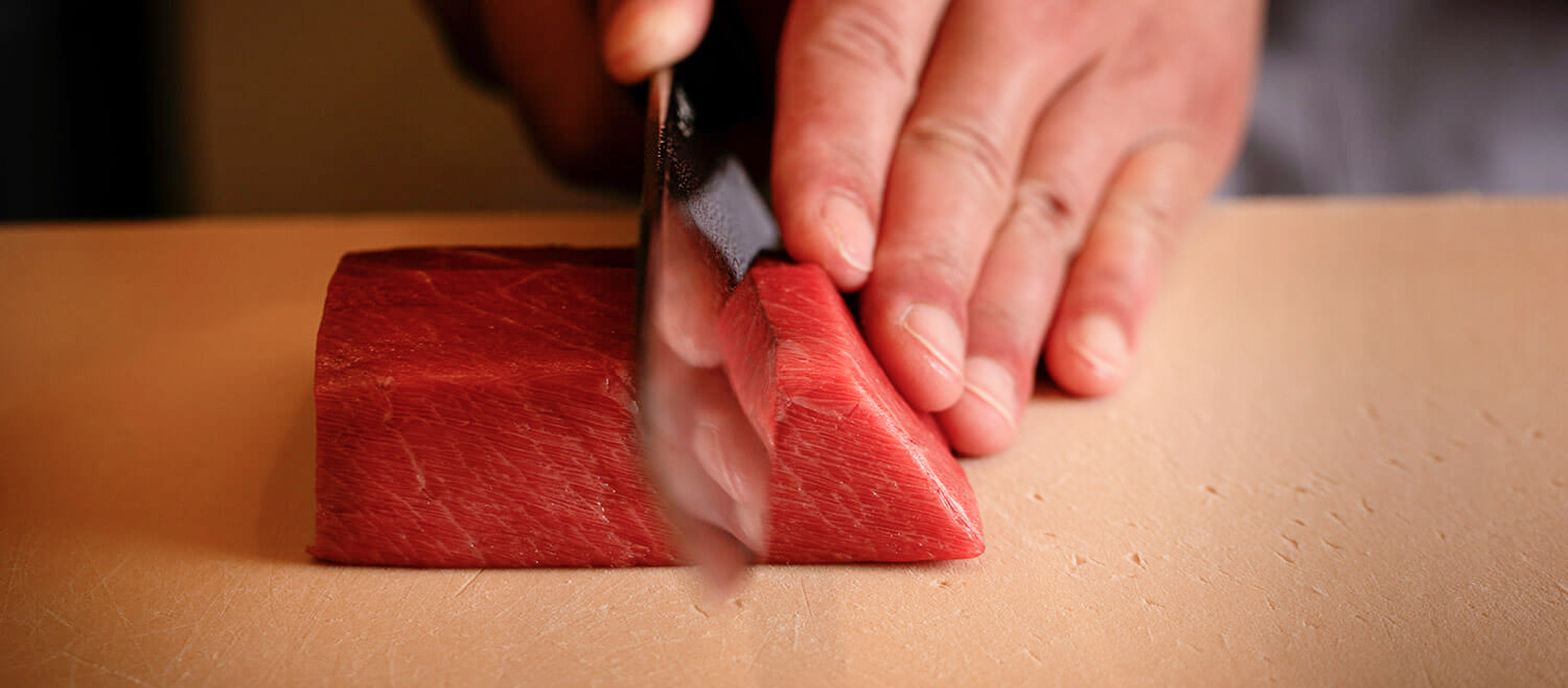 赤身の短冊を包丁で切る写真